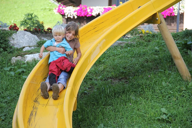 Kids playing on a yellow slide